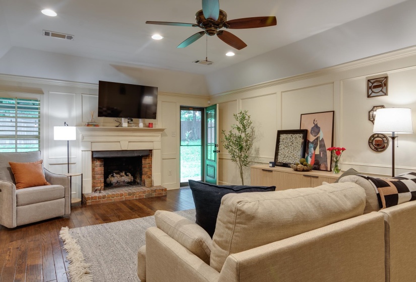 Living area featuring wood-finish flooring and a brick-surround fireplace with a classic mantel