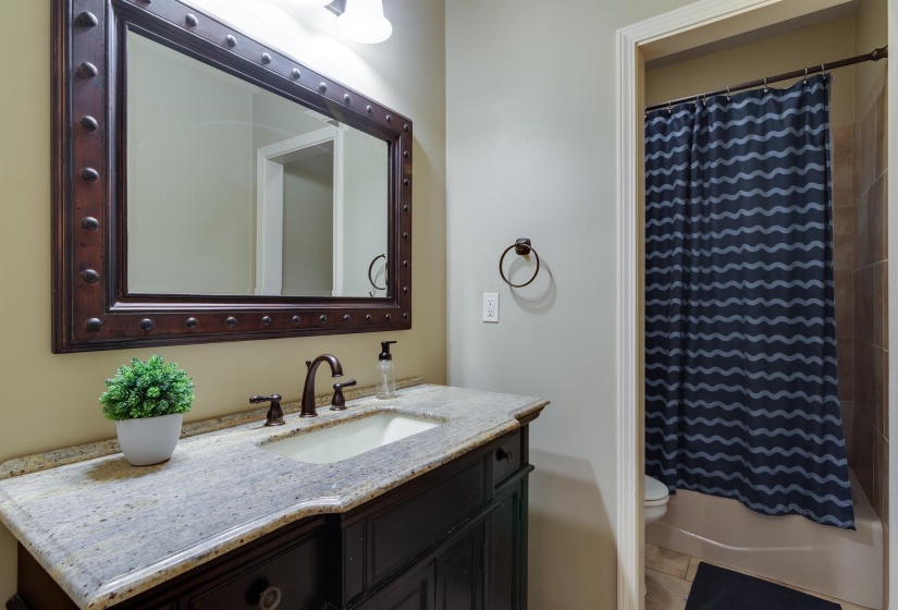 Bathroom featuring a dark wood vanity with a light speckled countertop and undermount sink