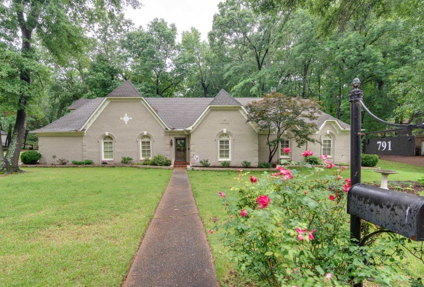 Traditional-style residence with a neutral-toned brick exterior and a dark shingle roof