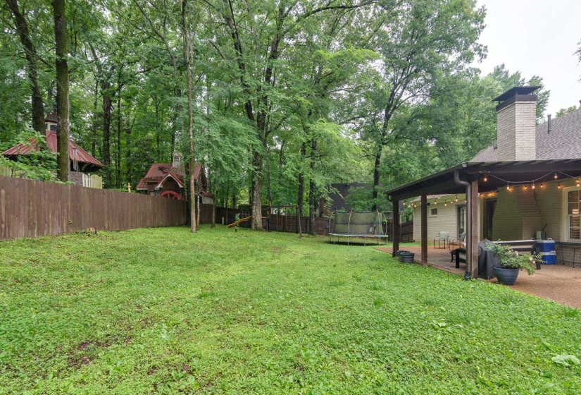 Expansive green lawn surrounded by mature trees