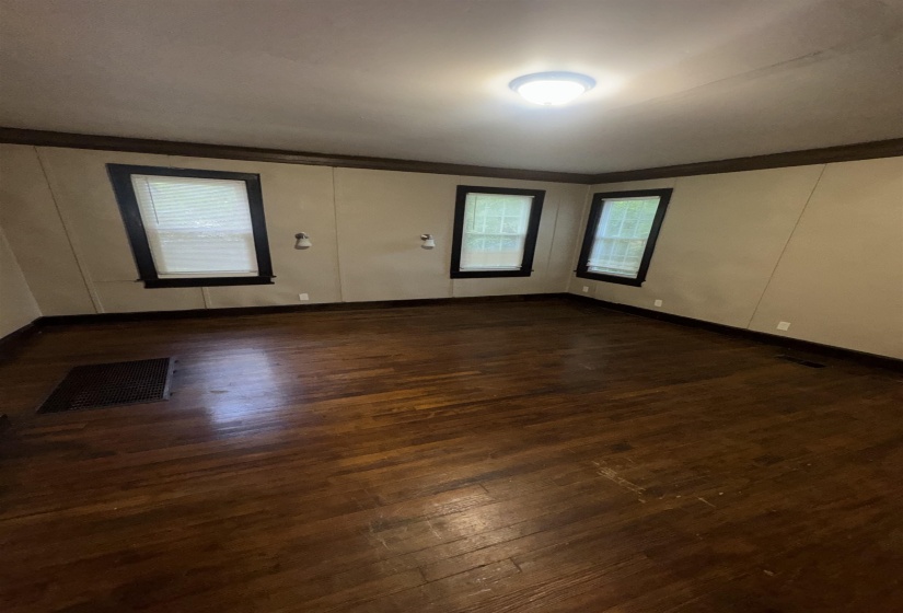 Hardwood flooring throughout featuring dark wood baseboards and trim