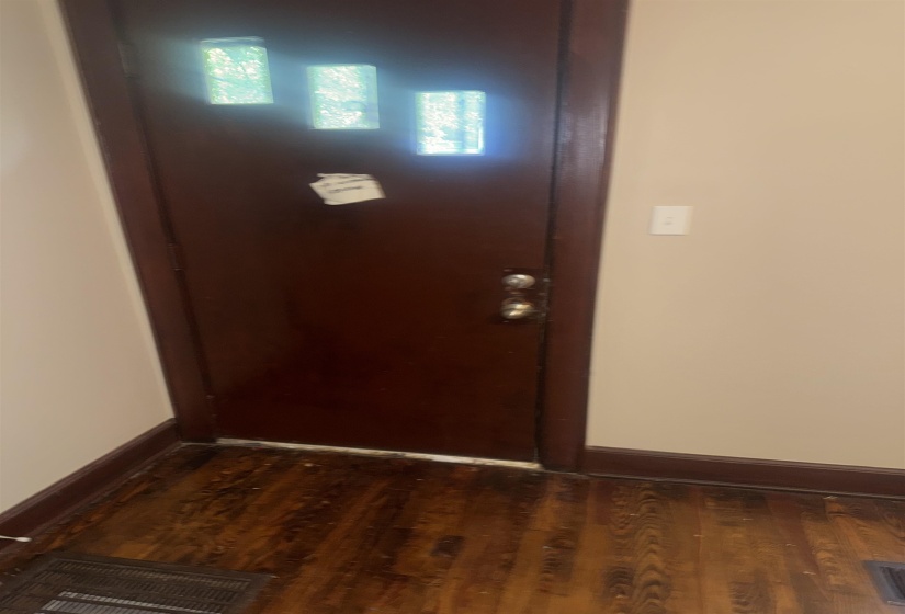 Dark wood-finish door with three rectangular glass inserts, complemented by dark wood-finish trim and wood-finish flooring