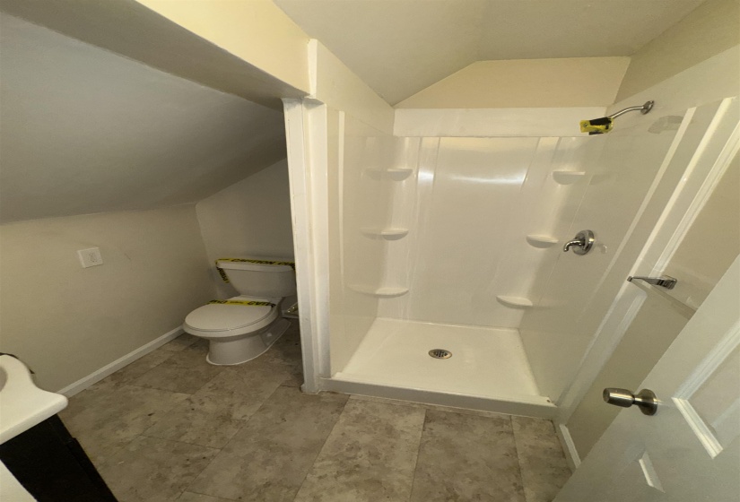 Walk-in shower with integrated shelving and chrome fixtures