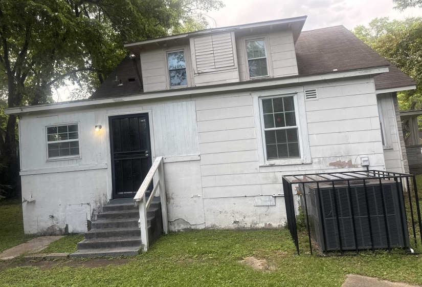 White siding exterior with black security screen door and exterior stairs
