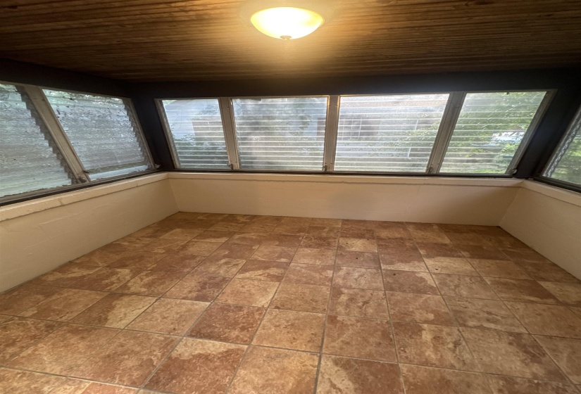 Enclosed porch with wood-finish ceiling and a flush-mount light fixture