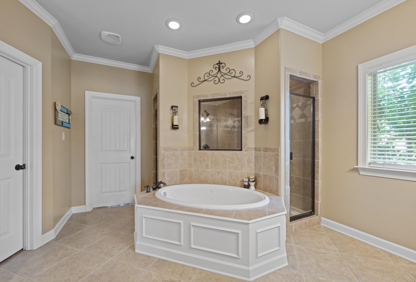 Spa-inspired primary bath with a relaxing whirlpool tub, separate tiled shower, elegant finishes, and a spacious layout designed for comfort and convenience.
