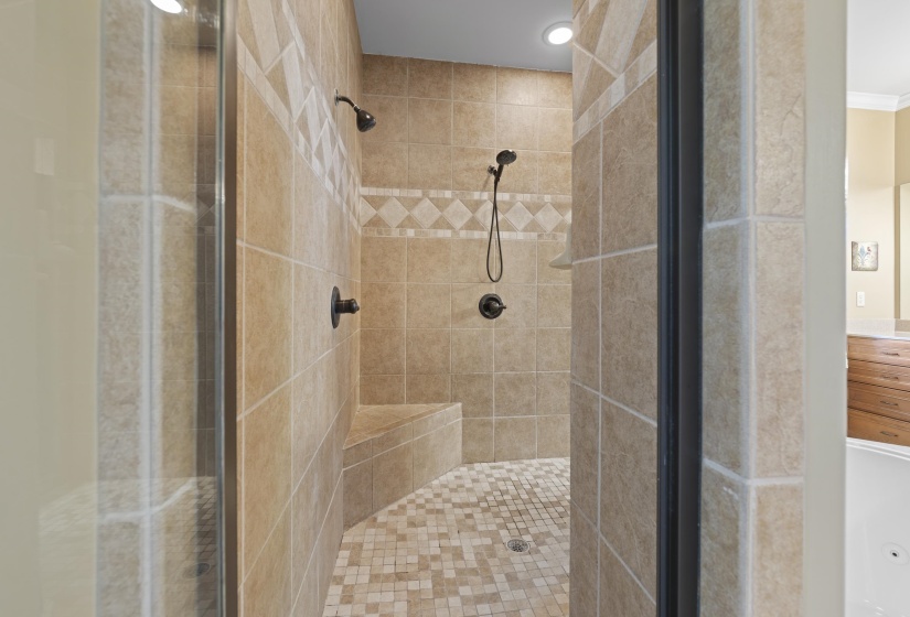Beautiful tiled walk-thru shower with built-in seating and stylish finishes creating a true spa-like experience.