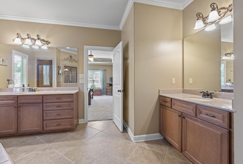 Luxury primary bathroom featuring separate vanities, ample storage, and an open spa-inspired design.