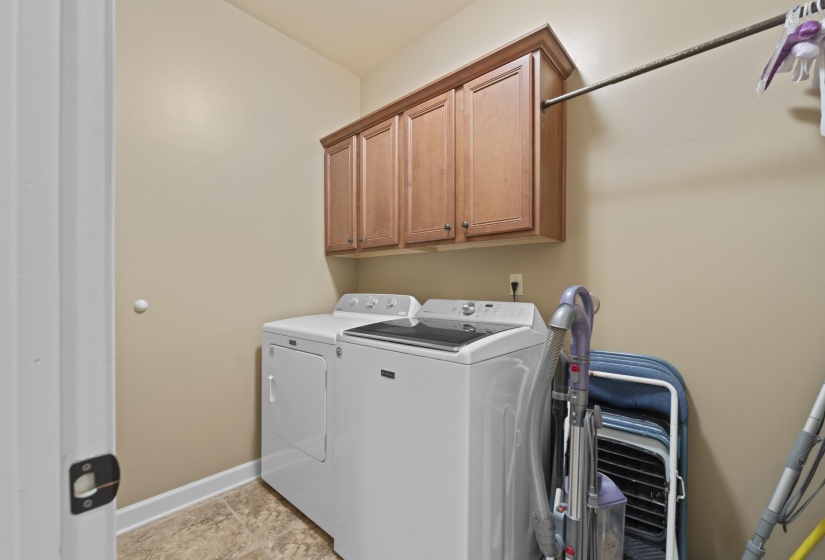 Functional laundry room with upper cabinetry and additional storage space to keep everyday tasks organized and convenient.