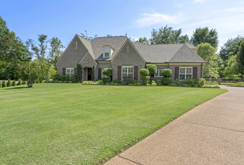 Charming brick exterior with professionally maintained landscaping, long driveway, and inviting front entry that welcomes you home.