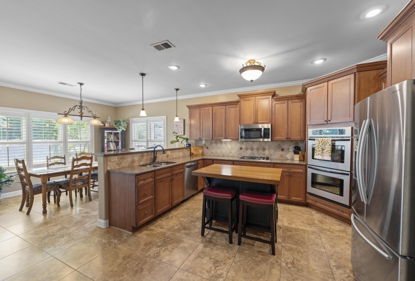 Kitchen features granite countertops, tile backsplash, center island, breakfast bar, pantry, and stainless steel appliances.