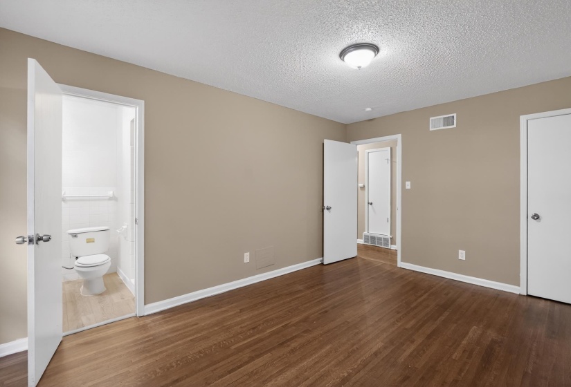 Interior room featuring wood-finish flooring, neutral wall paint, and white trim