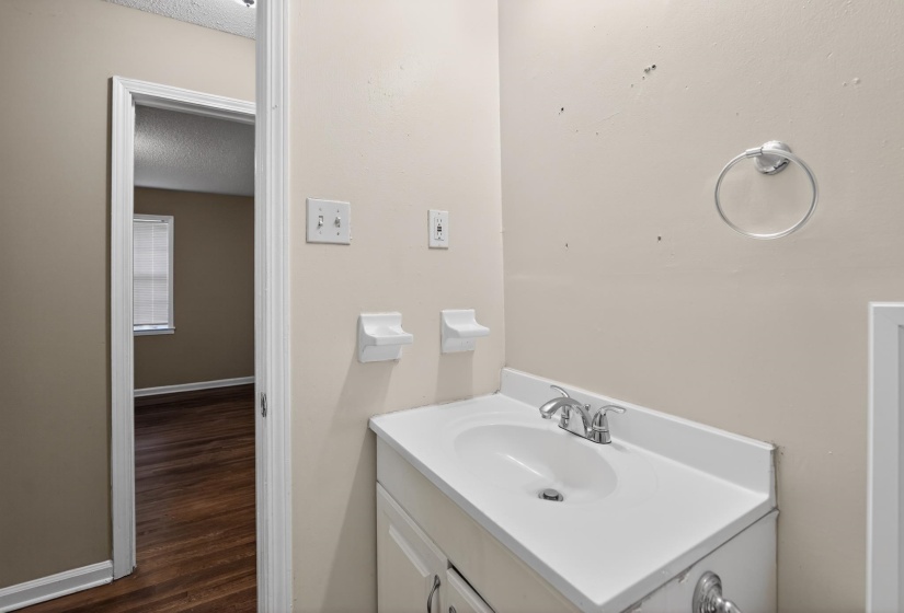 White single-basin vanity with an integrated countertop and chrome faucet