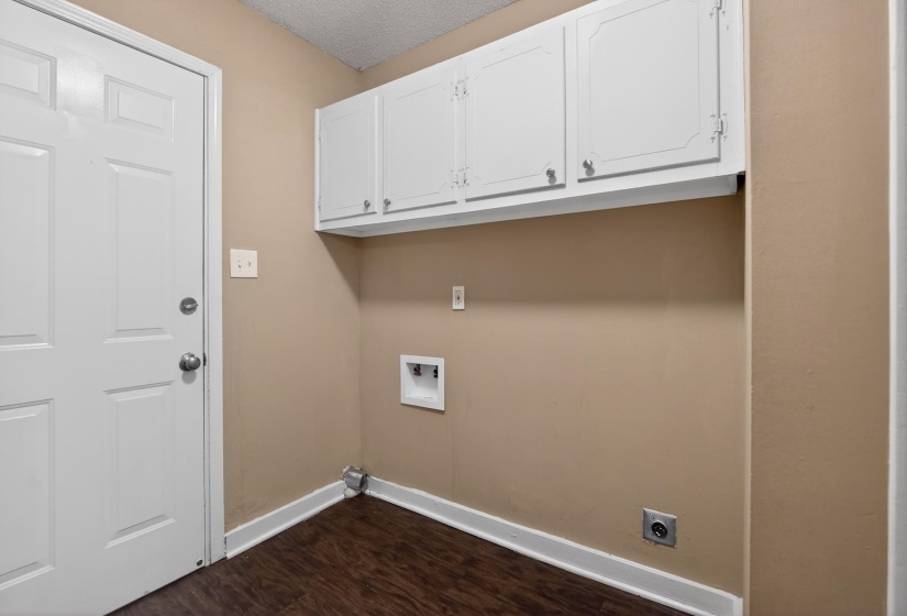 Dedicated laundry area featuring wood-finish flooring, white baseboards, and neutral wall paint