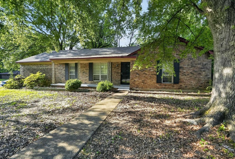Brick exterior with a covered porch featuring four columns and a decorative screen block wall