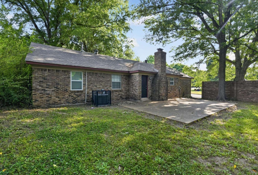 Brick exterior with a prominent brick chimney, accompanied by a concrete patio for outdoor enjoyment