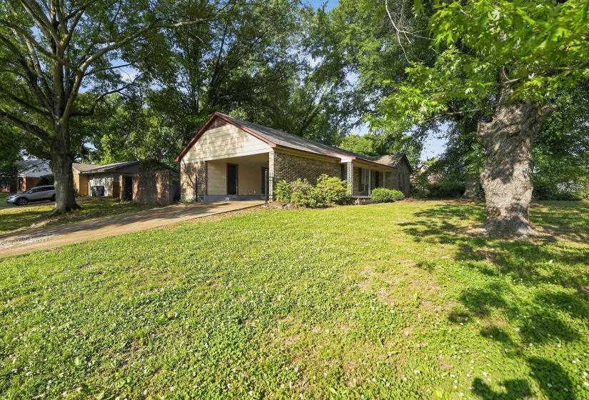 Ranch-style residence featuring brick and siding exterior construction, a covered carport, and a gravel driveway