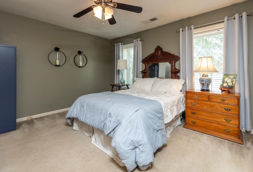 Bedroom featuring light carpet, a textured ceiling, and ceiling fan