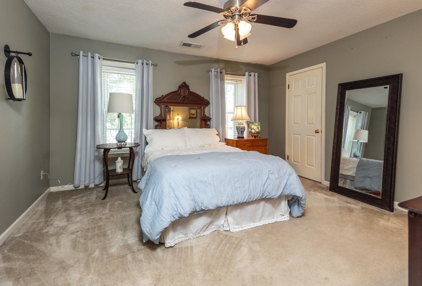 Carpeted bedroom with a textured ceiling and ceiling fan