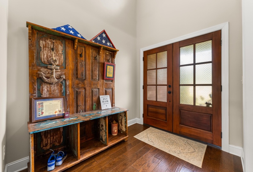 Entryway featuring wood-finish flooring, light neutral wall paint, and white baseboards