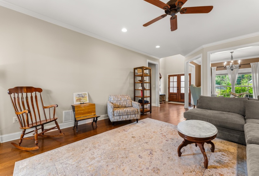 Hardwood-finish flooring throughout, crown molding, recessed lighting, and a ceiling fan with wood-finish blades