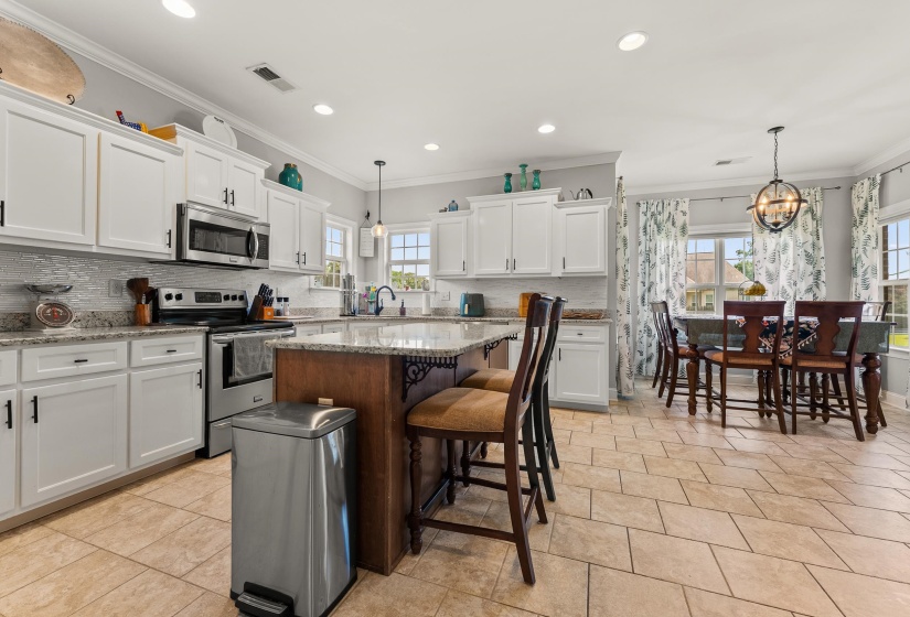 Kitchen featuring white cabinetry, stainless steel appliances, granite countertops, and a tiled backsplash