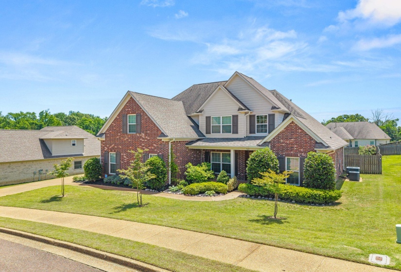 Two-story brick and siding residence featuring a gabled roofline and dark shutters