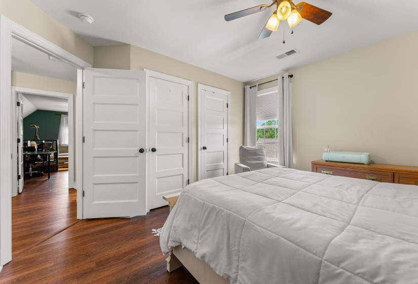 Bedroom featuring wood-finish flooring, a ceiling fan with integrated lighting, and neutral wall tones