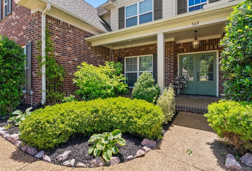 Brick exterior with a covered porch featuring white columns and a hanging lantern
