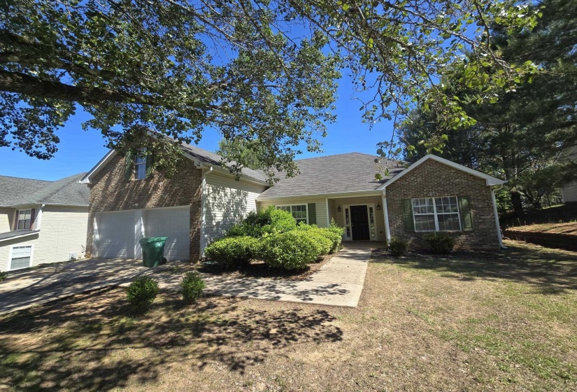 Traditional single-story home featuring a brick and siding exterior, an attached two-car garage, and a concrete walkway