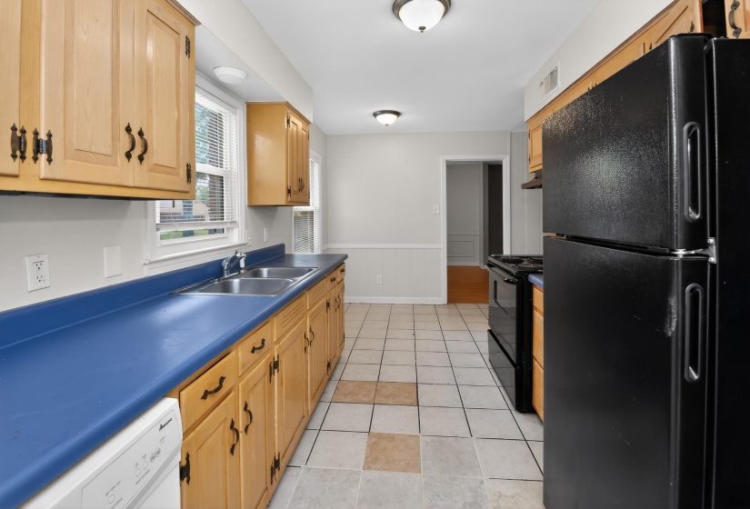 Kitchen with light wood-finish cabinetry, blue countertops, and a double basin stainless steel sink