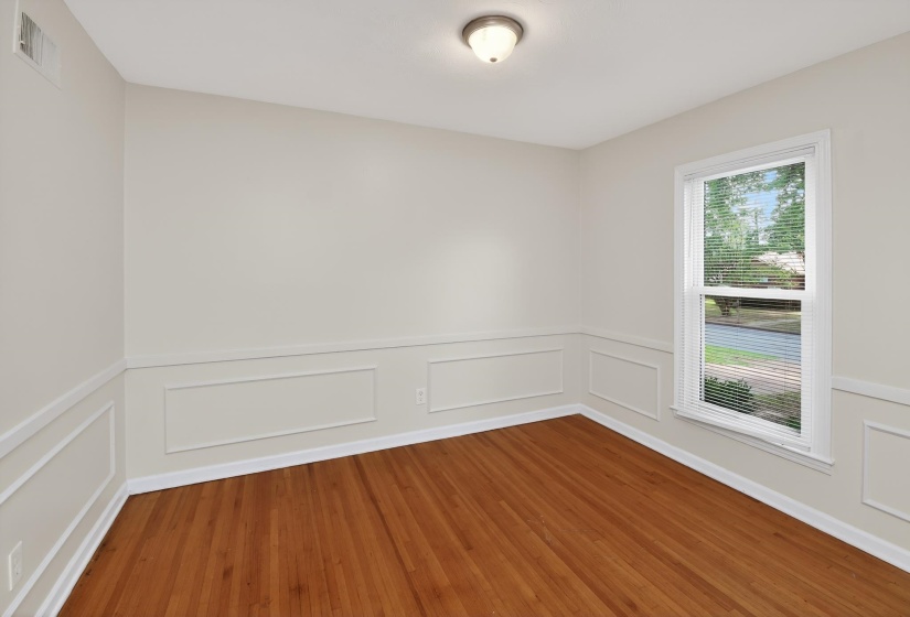 Interiors featuring wood-finish flooring, white paneled wainscoting, and a window with blinds