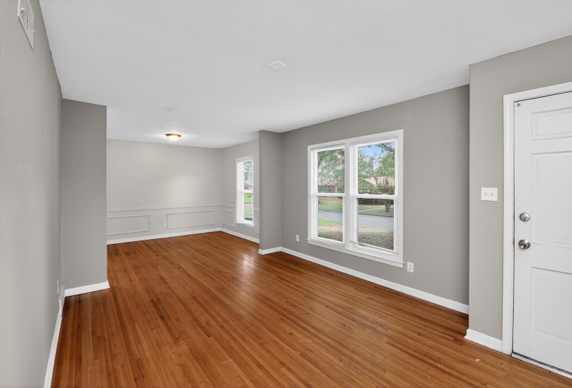 Spacious interior featuring wood-finish flooring, neutral gray walls, and white trim throughout