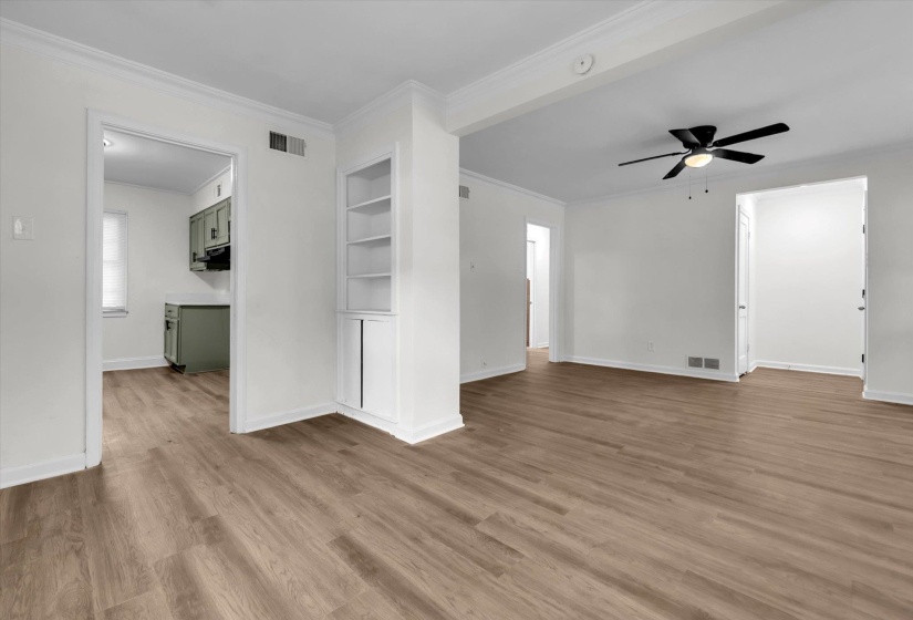 Spacious interior featuring wood-finish flooring, crisp white walls, and a contemporary ceiling fan with integrated lighting
