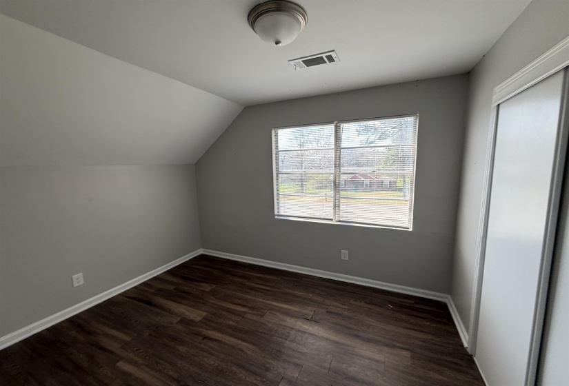 Interior room featuring wood-finish flooring, light grey painted walls, and white baseboards