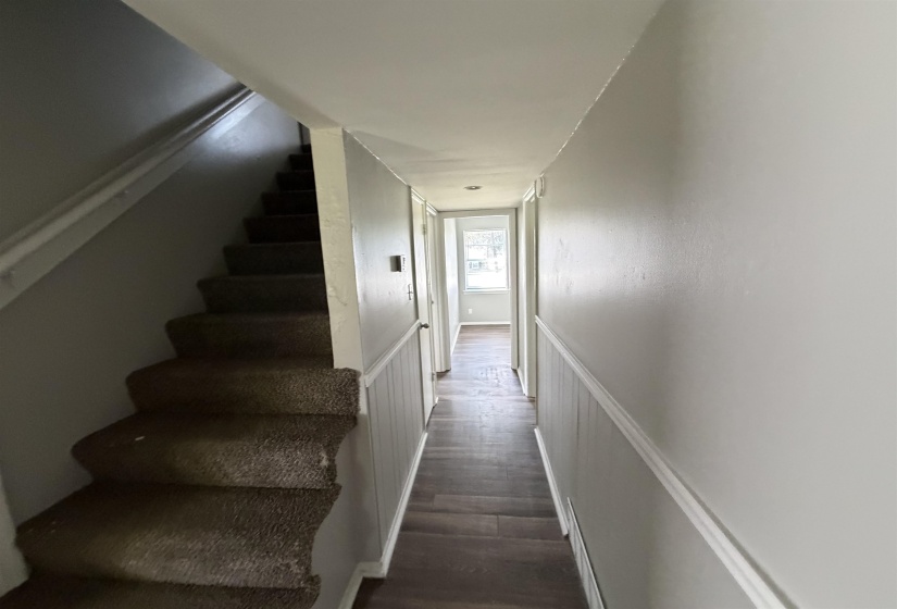 Carpeted staircase featuring a painted handrail