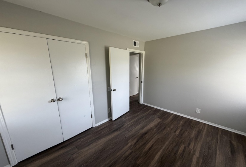 Room featuring wood-finish flooring, light gray wall paint, white trim, and a semi-flush ceiling light fixture