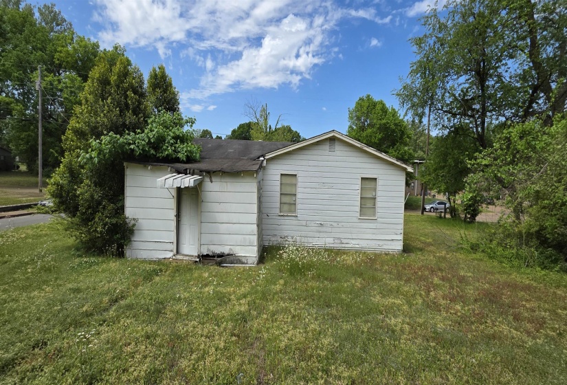 White siding exterior with a dark shingle roof and a front door awning