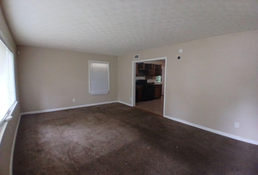 Interior room featuring neutral wall paint, white trim, and textured ceiling