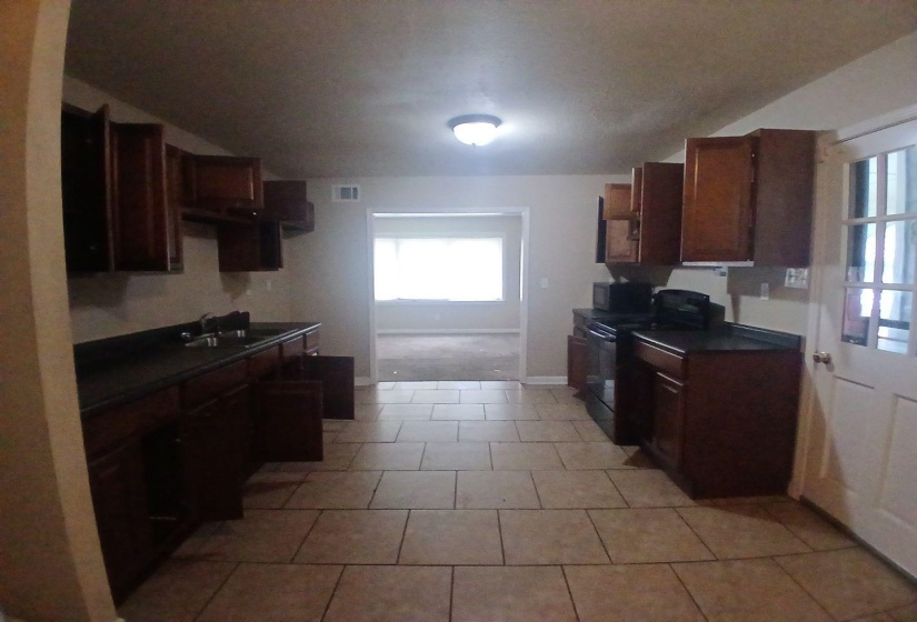 Kitchen with tile flooring and wood-finish cabinetry