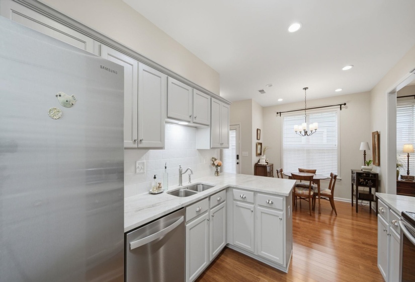Kitchen featuring stainless steel appliances, light gray shaker cabinetry, white subway tile backsplash, and light-toned countertops
