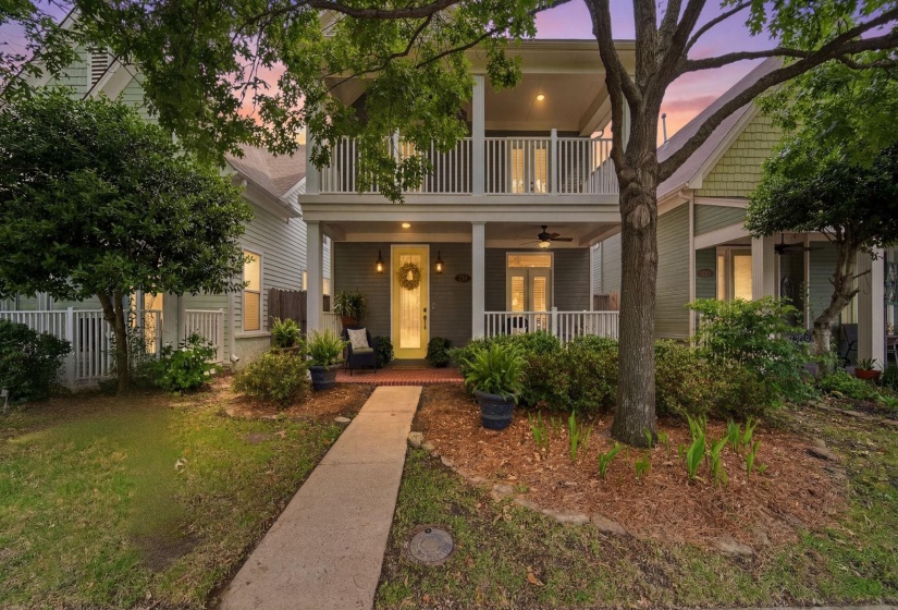 Two-story residential exterior featuring a prominent two-tiered porch with white railings