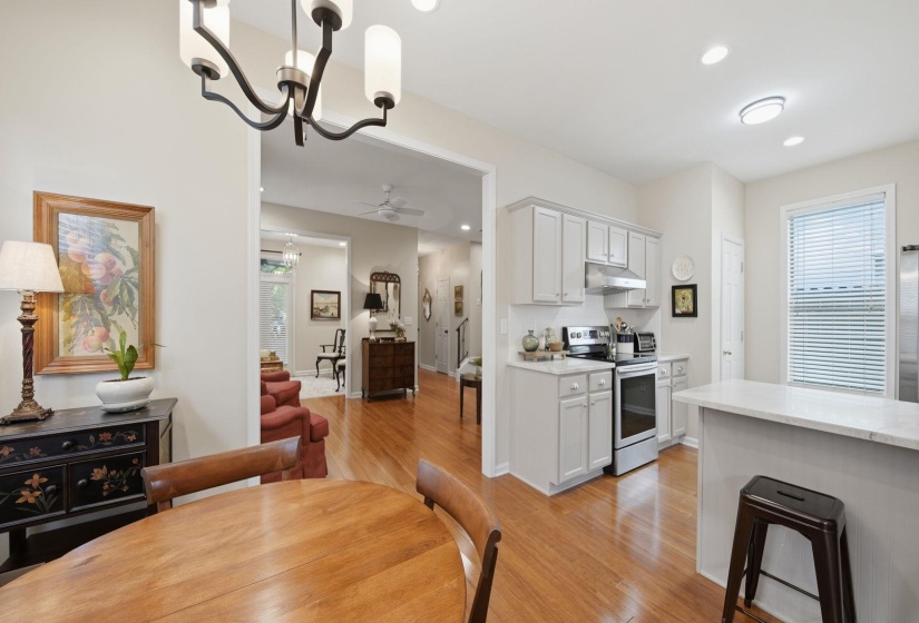 Dining area featuring wood-finish flooring, a contemporary chandelier, and an open concept layout into the kitchen