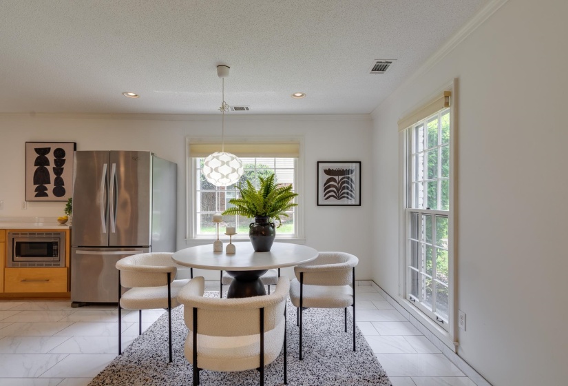 Bright dining area featuring a modern pendant light fixture and white trim windows