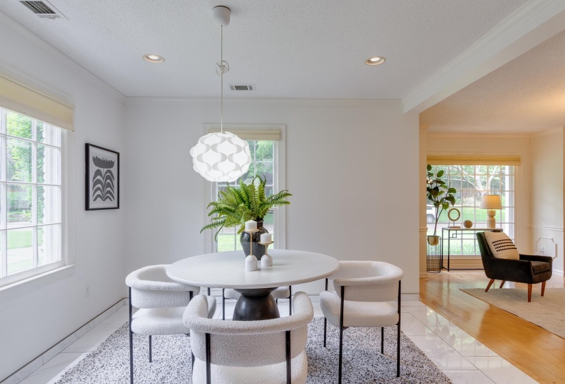 Dining area featuring a contemporary pendant light, recessed lighting, crown molding, and large window with exterior foliage