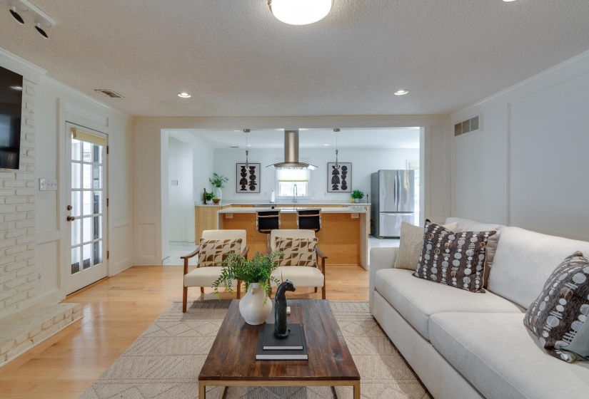 Bright living area with light wood-finish flooring and white board and batten wall details