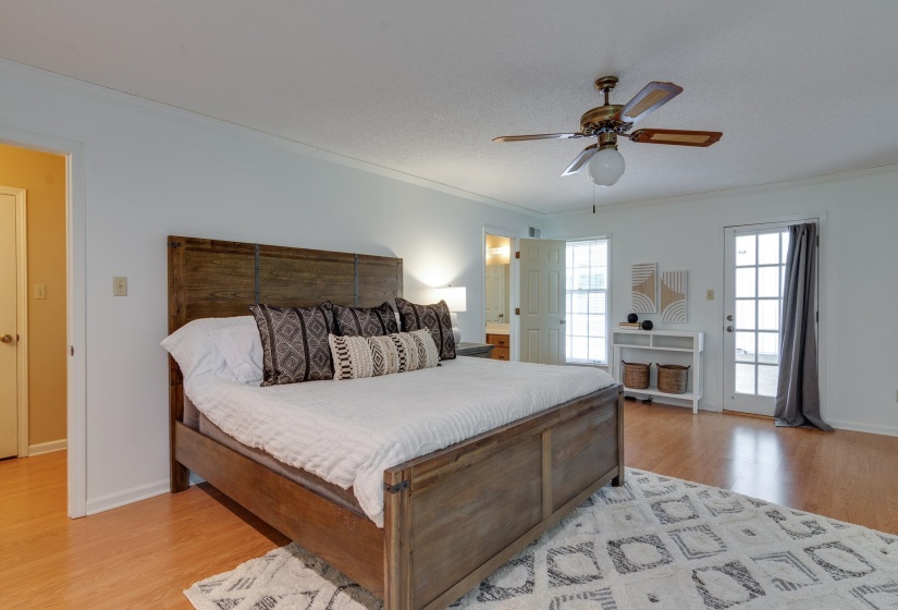 Spacious room featuring wood-finish flooring, a ceiling fan, and white trim throughout
