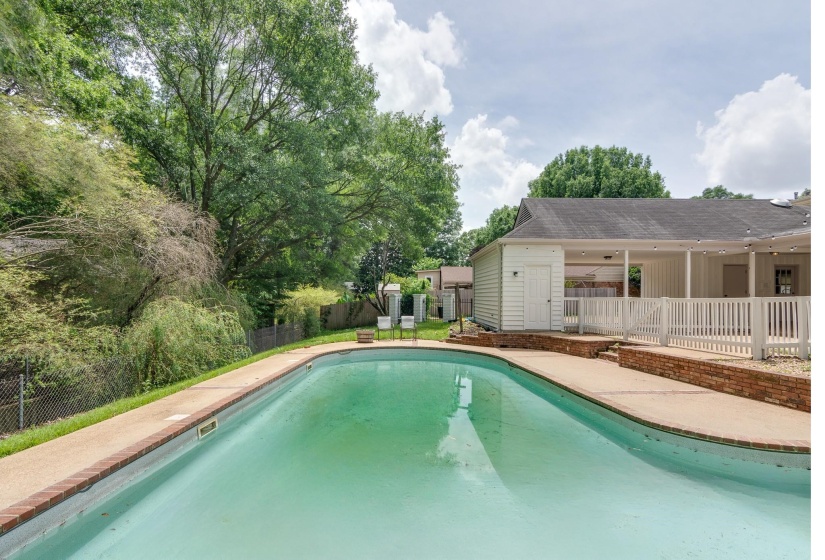 In-ground swimming pool with concrete surround