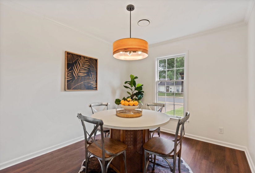 Dining area featuring wood-finish flooring, white walls, and a multi-pane window