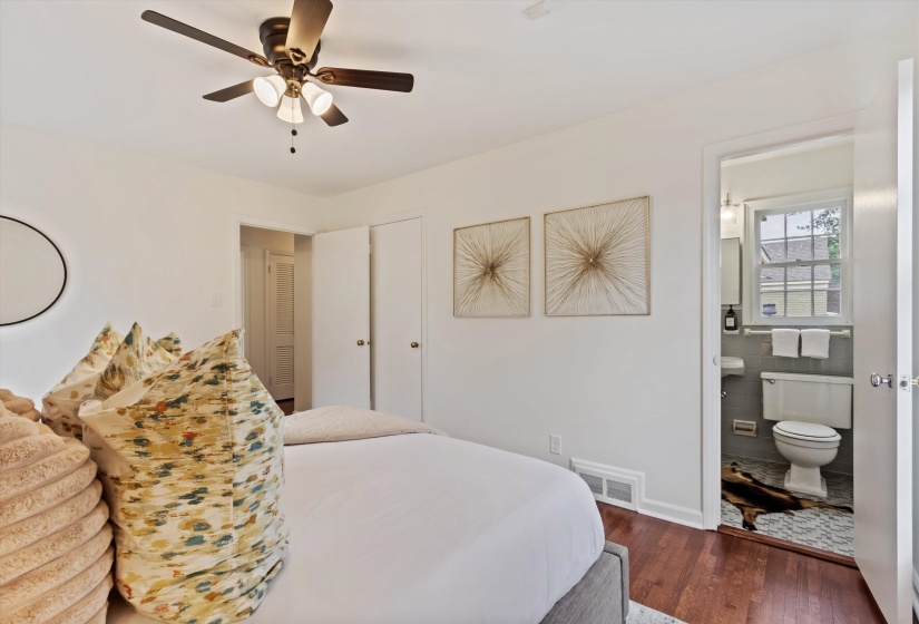 Bedroom featuring hardwood flooring, a ceiling fan with integrated lighting, and two built-in closet doors